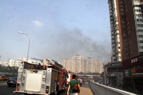 北京朝阳一餐厅二层楼顶着火 消防队员紧急扑救