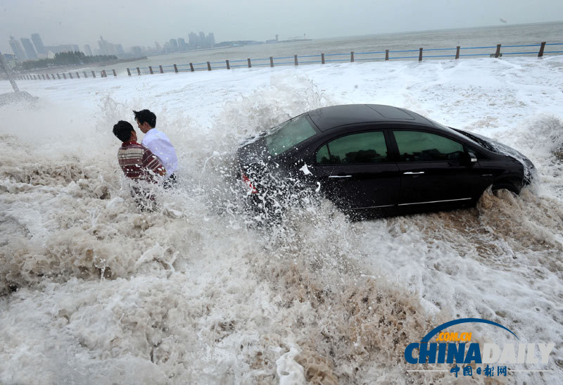 台风袭来青岛海域掀巨浪 民警斩浪救车