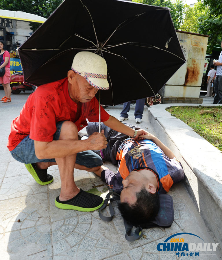 湖北汉口：68岁老人跪地营救晕倒男子