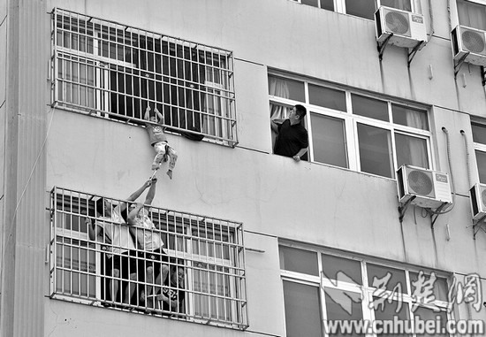 武汉:男孩头卡防盗网 “托举哥”窗外凌空救人