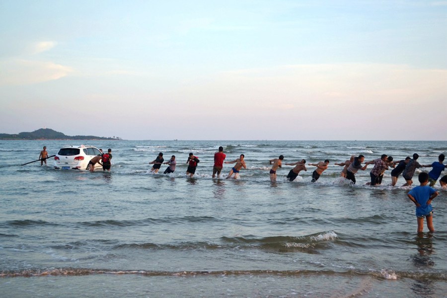 轿车陷入沙滩 众人“拔河”救车