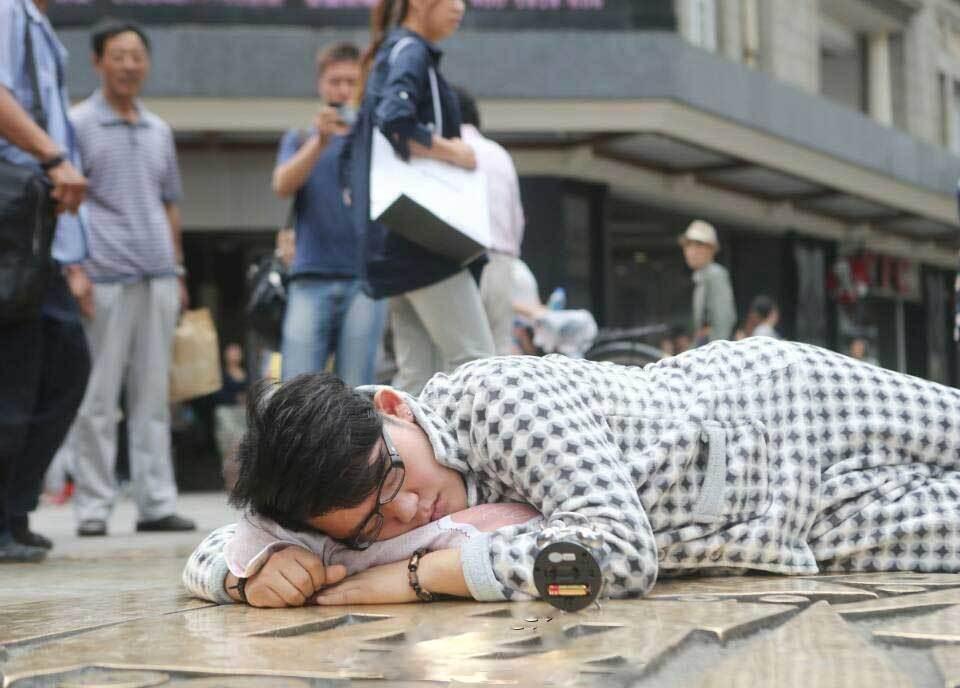 天津一大学生自备枕头闹钟趴闹市街头睡觉