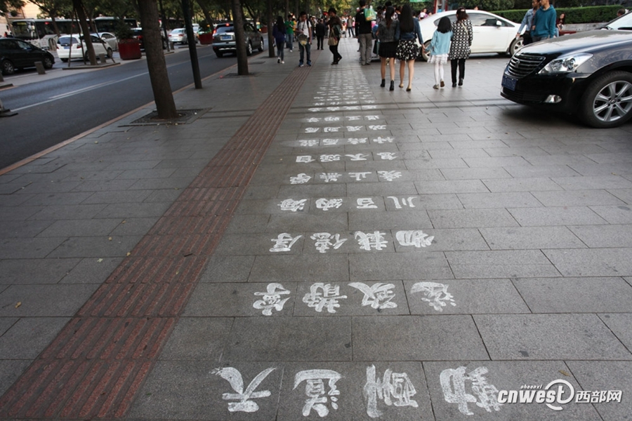 云南无臂人西安街头用脚写百米地书 展示一脚好字