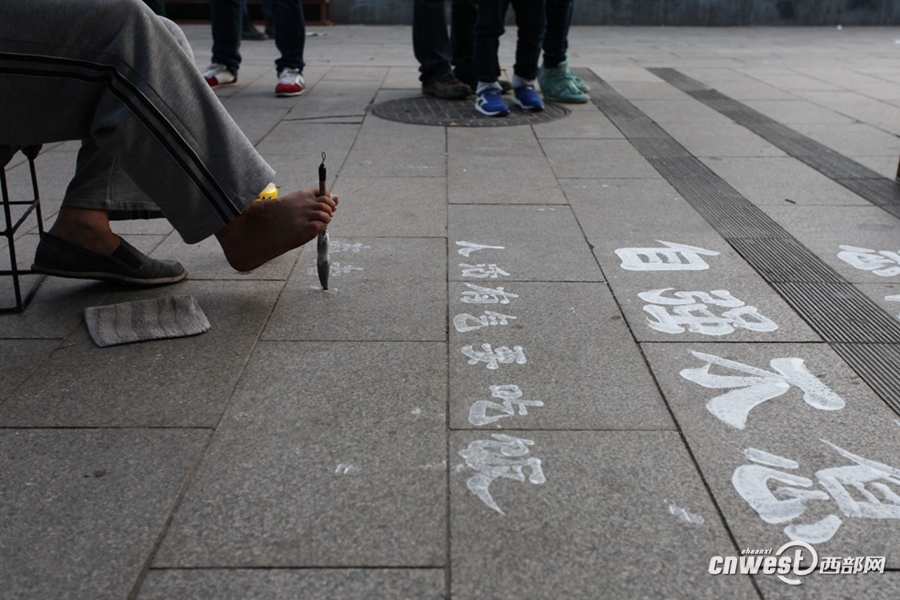 云南无臂人西安街头用脚写百米地书 展示一脚好字