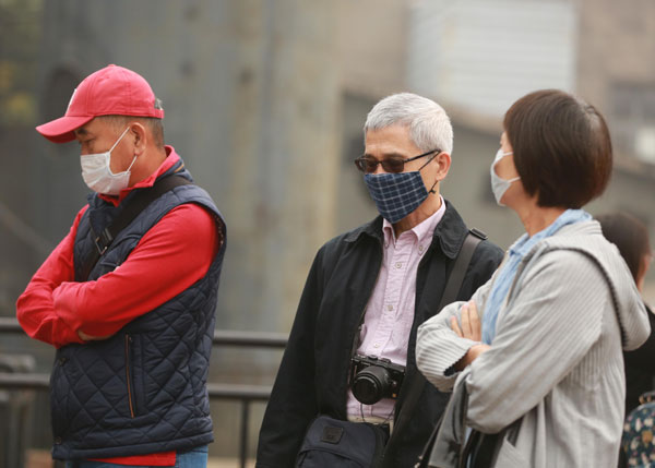 雾霾笼罩北京城区 行人戴口罩出行
