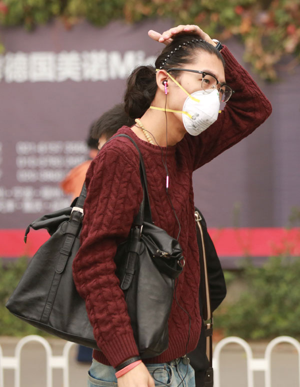 雾霾笼罩北京城区 行人戴口罩出行