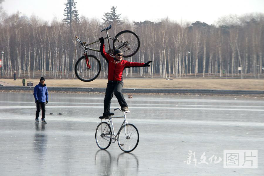 长春：车王冰面站立举单车骑行
