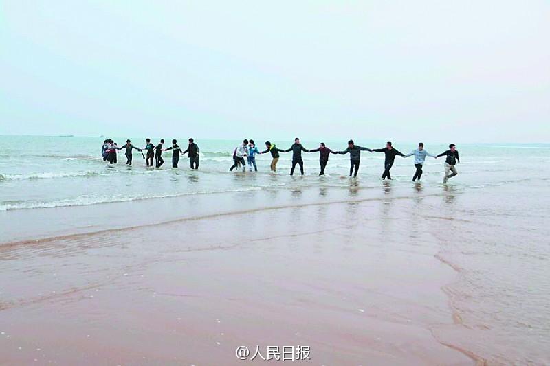 秦皇岛18名大学生手挽手冲进大海救出女子