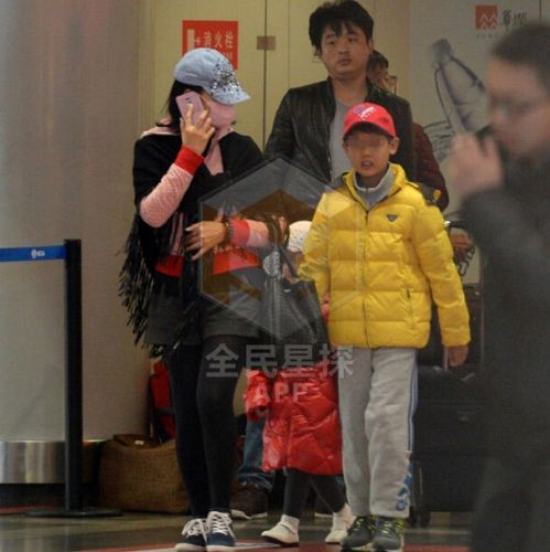 宋祖英携两个孩子现身机场被拍 遮面前行仍很瘦