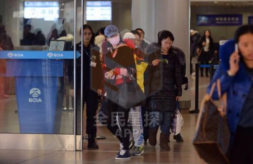 宋祖英携两个孩子现身机场被拍 遮面前行仍很瘦