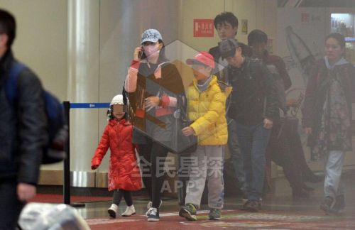 宋祖英携两个孩子现身机场被拍 遮面前行仍很瘦