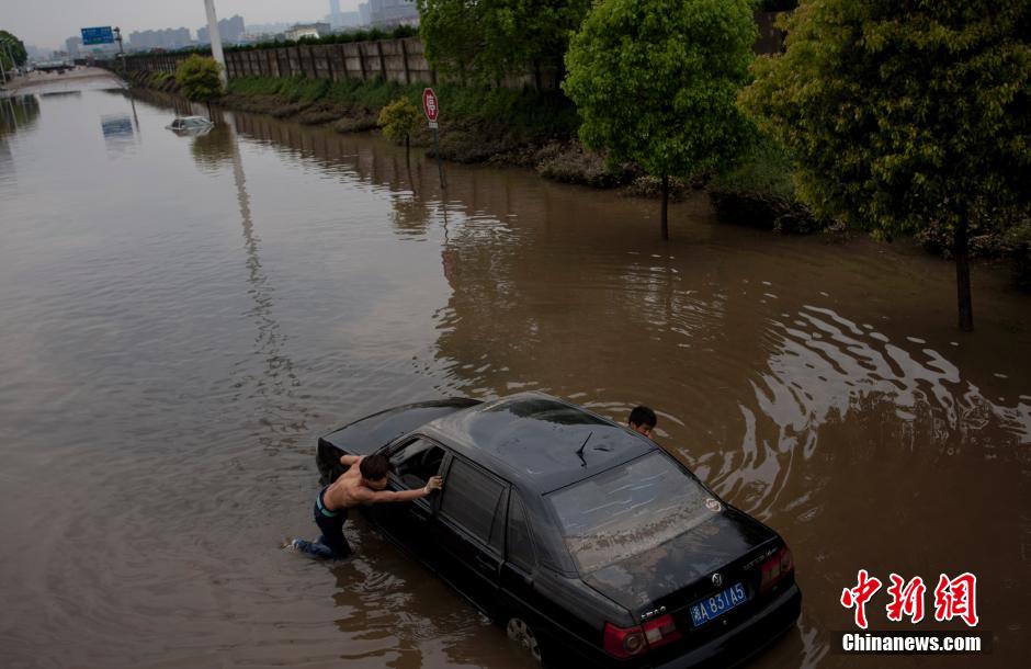 长沙城区马路变河 被淹车主花3000元拖车
