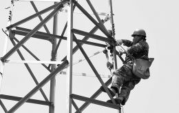 古县供电公司抢修人员在铁塔上固定拉线抱箍