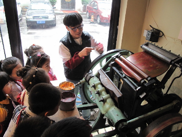 青岛小学生转动印刷老机器制作贺卡 表达对妈妈节日祝福