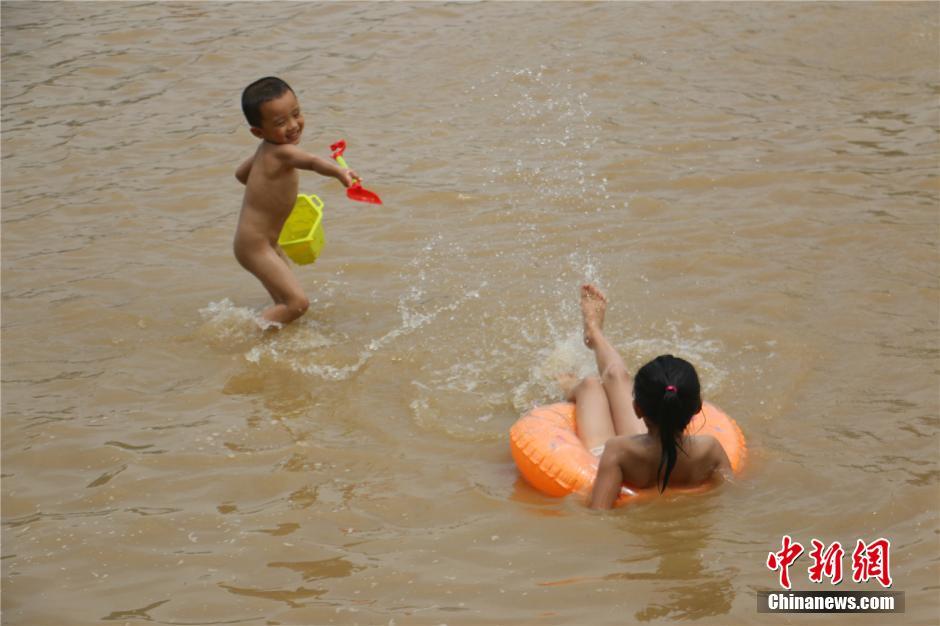 广西暴雨至柳江河水上涨 市民水中作乐