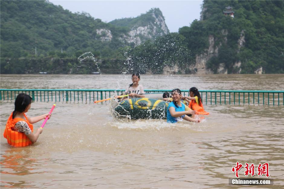 广西暴雨至柳江河水上涨 市民水中作乐