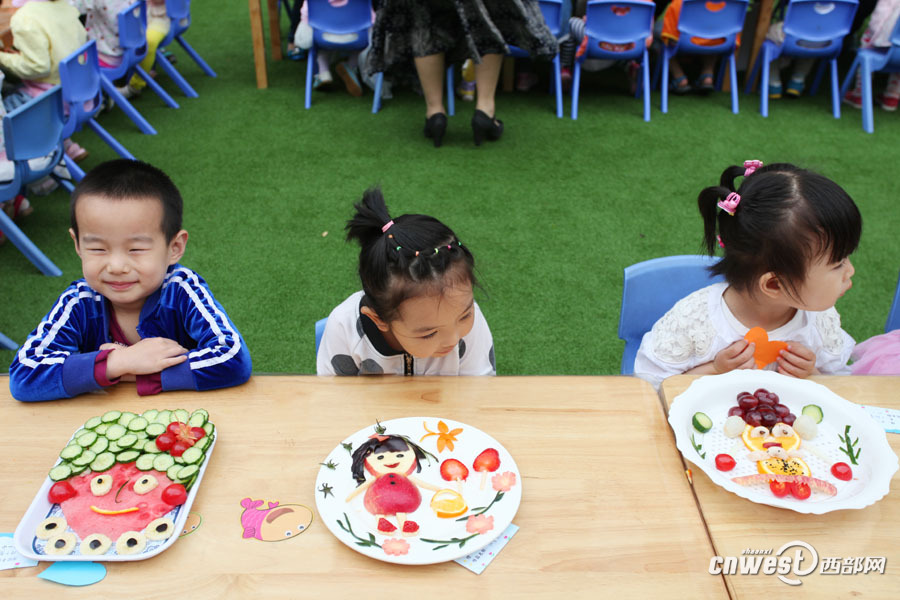 幼儿园里家长和孩子一起用水果拼出童真