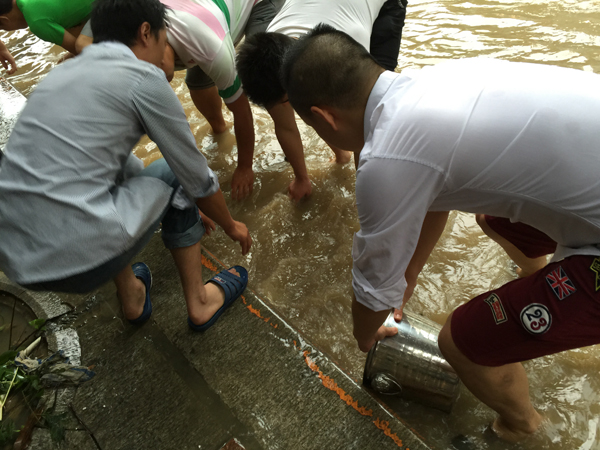 台风“苏迪罗”过去 福州市民街头争相捉鱼水中作乐