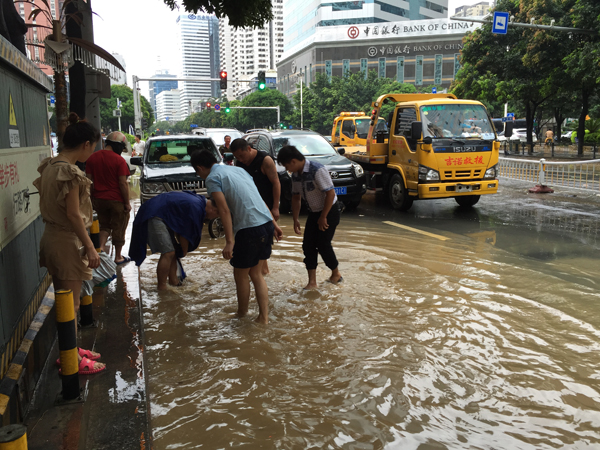 台风“苏迪罗”过去 福州市民街头争相捉鱼水中作乐