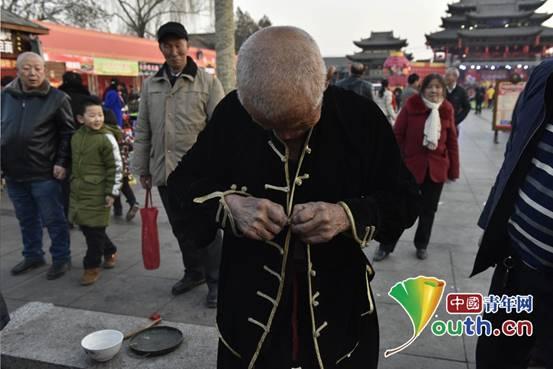 惊！山西榆次一83岁老人街头展绝活手指能把碗片捏成粉末