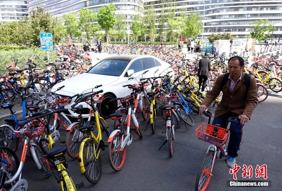 北京共享单车数量激增 汽车路边被“围堵”