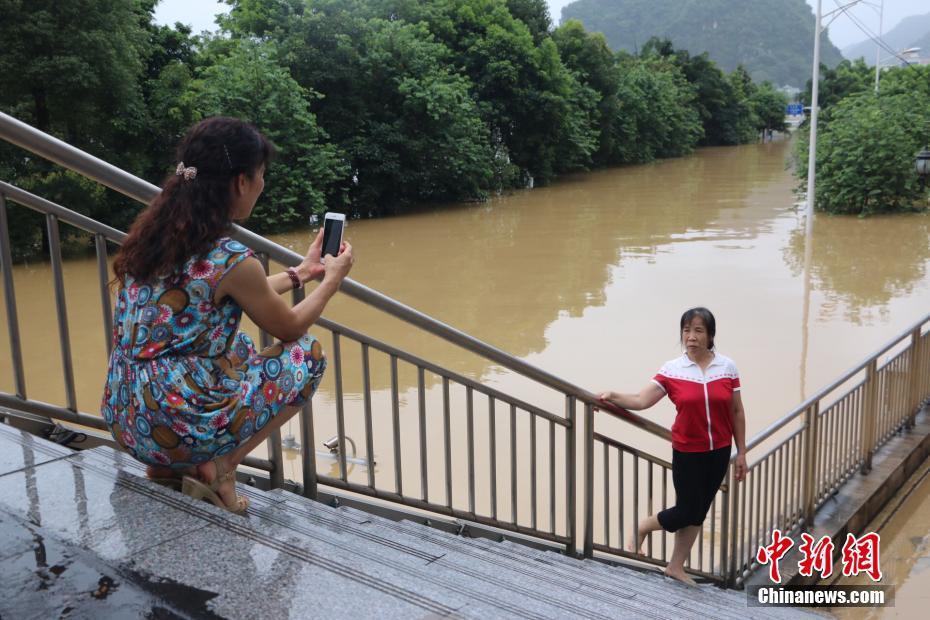 洪峰过境广西柳州 民众水中划船抓鱼