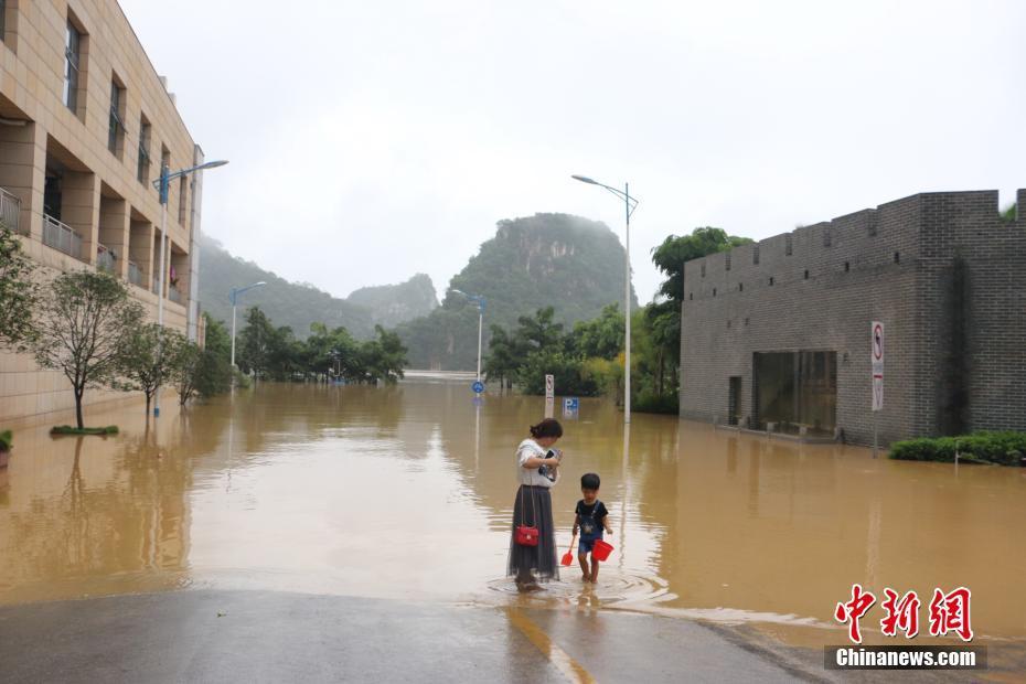 洪峰过境广西柳州 民众水中划船抓鱼