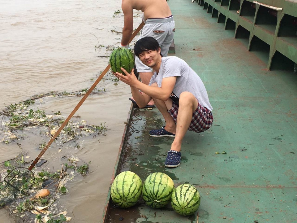 连续降雨后 一船民在江里捞出一堆瓜