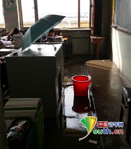 山西朔州一中教室漏雨 老师撑伞给学生上课