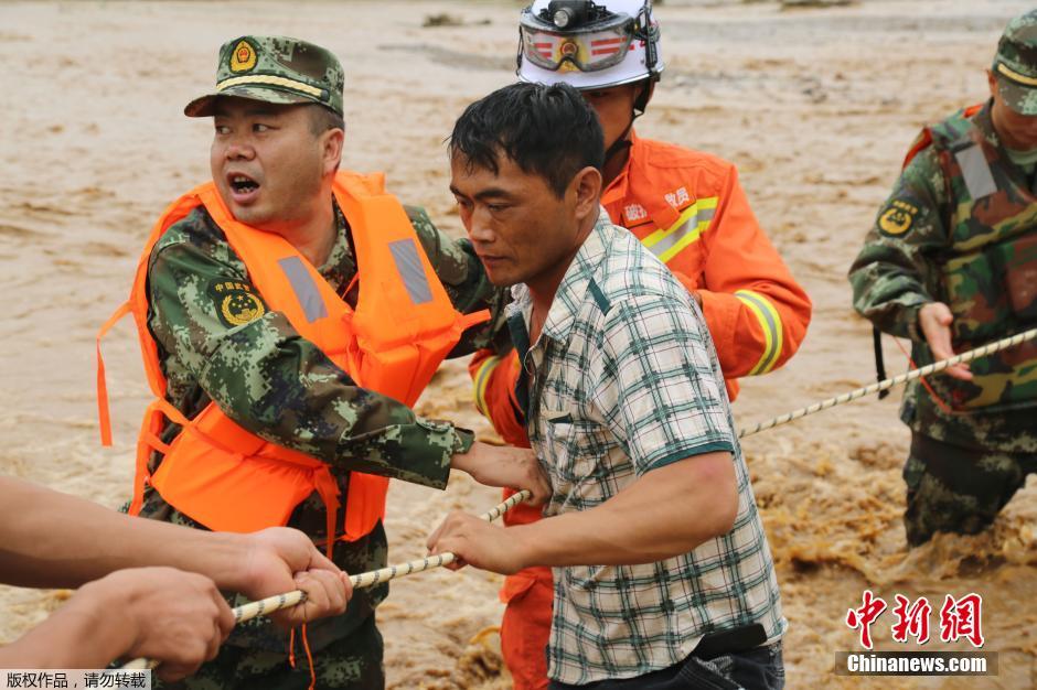 云南文山强降雨民众被困 消防官兵渡河救援