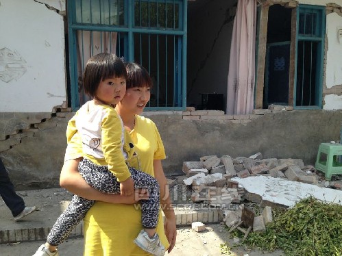 地震后墙壁出现窟窿 女子抱3岁女儿幸运逃生(图)