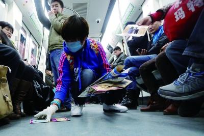 北京志愿者地铁10号线内3小时清理广告400斤