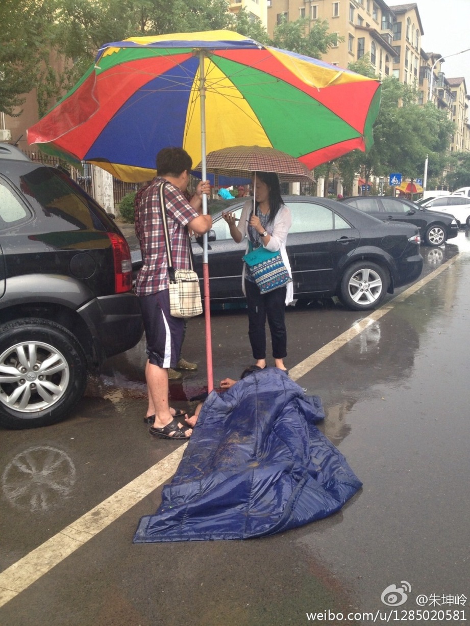 老人雨中被撞 路人撑伞等救援