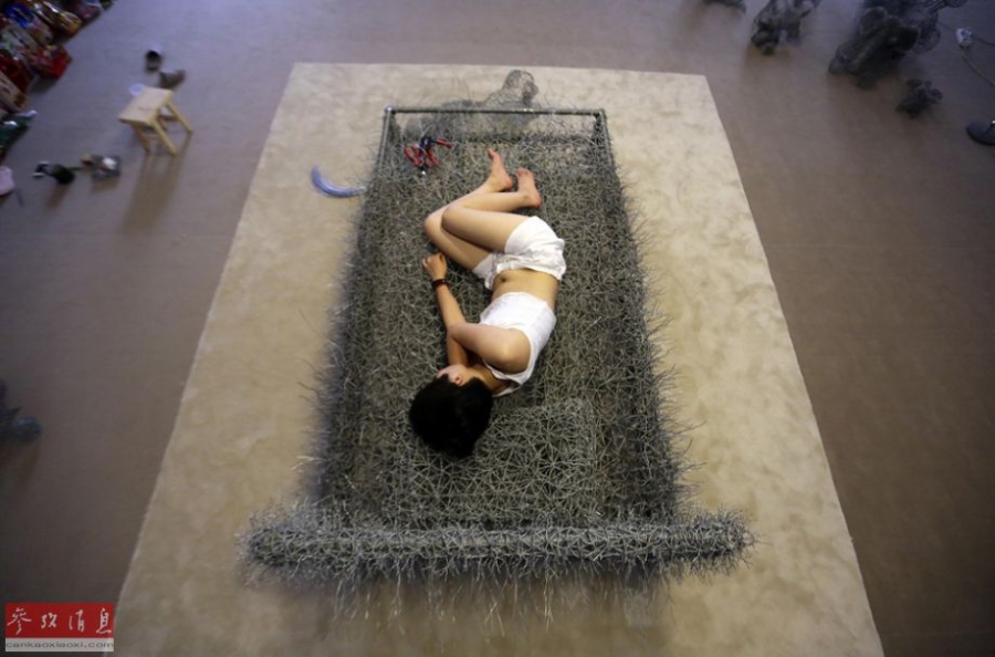 中国女艺术家“裸睡”铁丝床36天