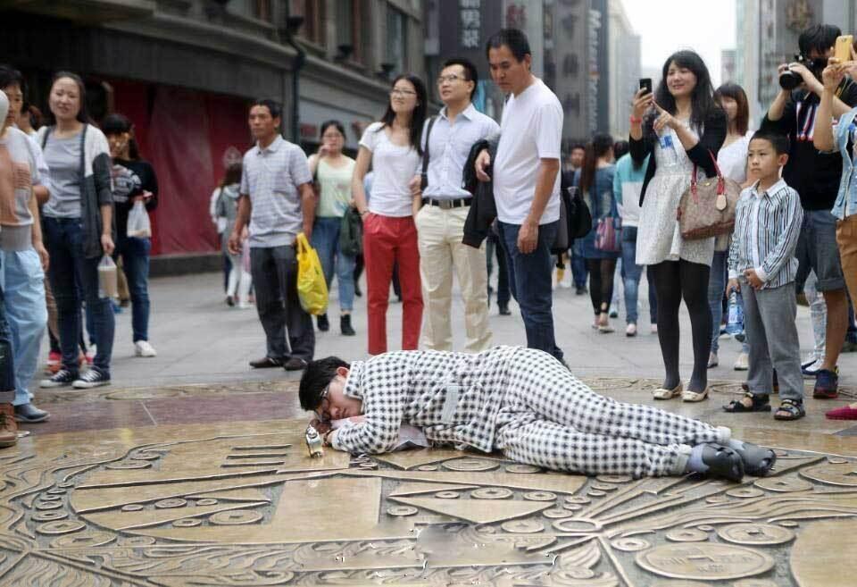 天津一大学生自备枕头闹钟趴闹市街头睡觉