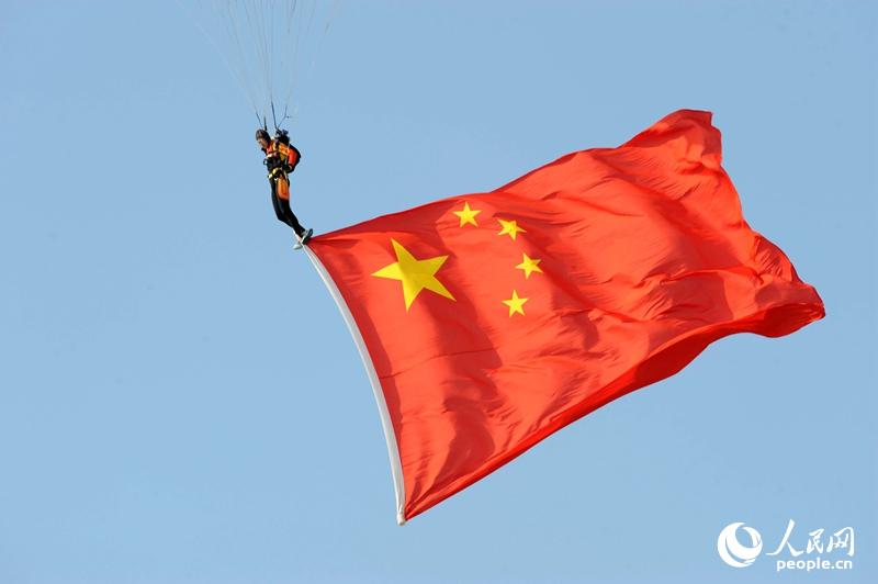 跳伞选手在空中展示国旗