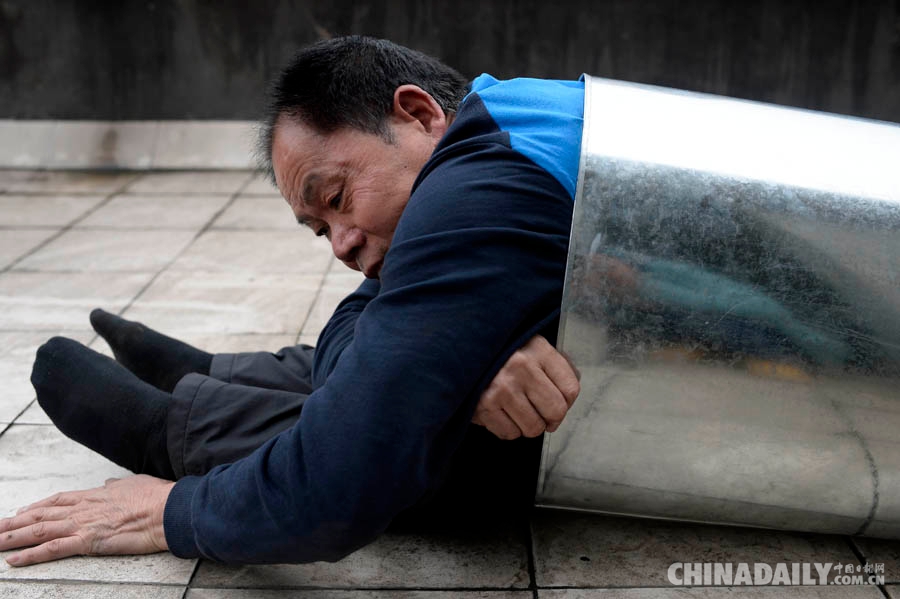 重庆58岁老汉练习“缩骨功” 每天钻铁桶健身