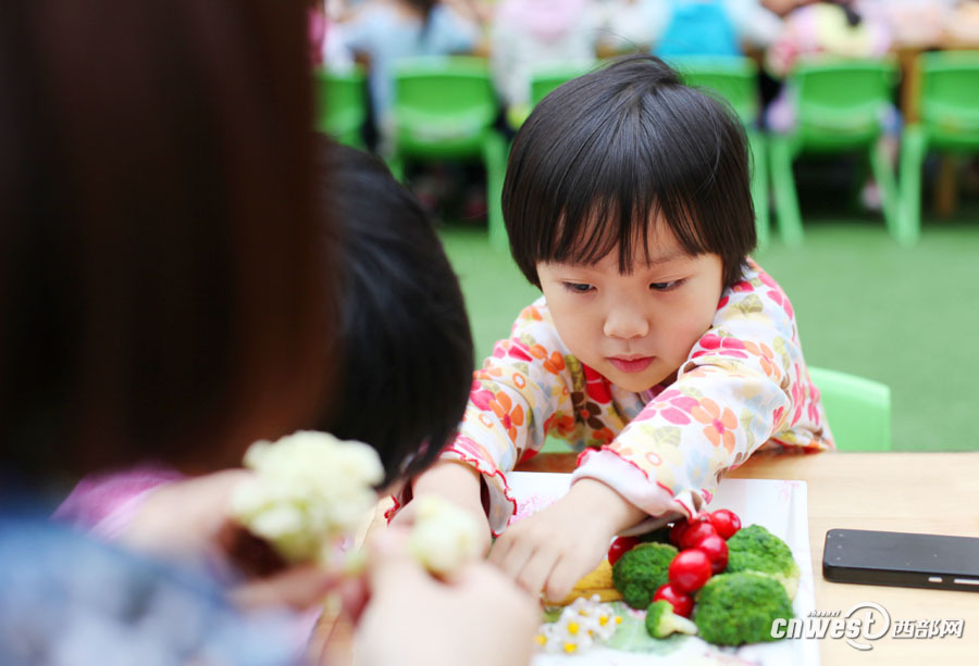 幼儿园里家长和孩子一起用水果拼出童真