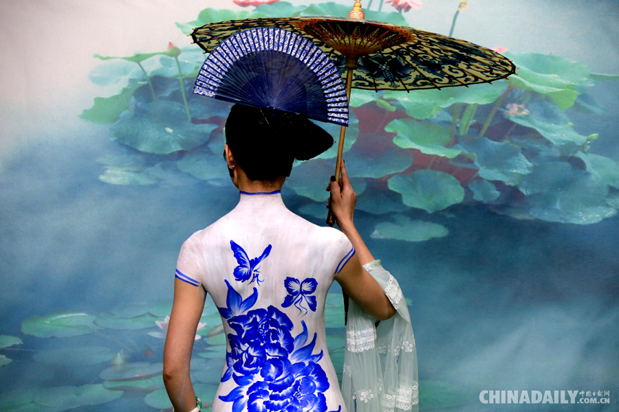6月20日,一名模特在黄山芙蓉谷风景区上演《青花旗袍》人体艺术彩绘